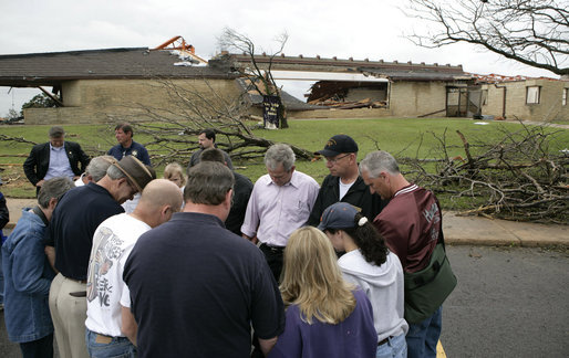 President George W. Bush joins townspeople in prayer Wednesday, May 9, 2007, as he toured a neighborhood in the tornado-ravaged community of Greensburg, Kansas. At least 10 people died in the Friday night storm that destroyed nearly 95 percent of the town. White House photo by Eric Draper
