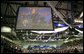 President George W. Bush is shown at the podium in an overhead screen Saturday, April 28, 2007, as he stands onstage at Miami Dade College - Kendall Campus in Miami and delivers the 2007 commencement address. White House photo by Eric Draper