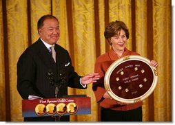 Mrs. Laura Bush and U.S. Mint Director Ed Moy hold up the Dolly Madison Gold Coin Monday, Nov. 19, 2007, in the East Room. "Today, we're paying tribute to an amazing First Lady, and an extraordinary woman, with the Dolly Madison Gold Coin," said Mrs. Bush. "Over the last year, since the U.S. Mint launched the First Ladies series, these coins have been extremely popular: The likenesses of Martha Washington, Abigail Adams, and Jefferson's Lady Liberty sold out within hours of their release. Their appeal reflects the enthusiasm of America's coin collectors, the public's fascination with American history, and Americans' interest in our remarkable First Ladies." White House photo by Joyce N. Boghosian