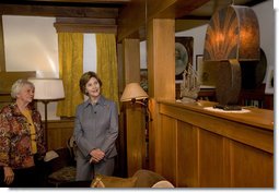 Mrs. Laura Bush admires a steel lamp at the Mansfield, Mo., home of Laura Ingalls Wilder. Mrs. Jean Coday, Director and President of the Laura Ingalls Wilder Historic Home and Museum, explains that the lamp originally belonged to the well-known author's sister. This week the Laura Ingalls Wilder Historic Home and Museum was designated a Save America's Treasures project. White House photo by Chris Greenberg