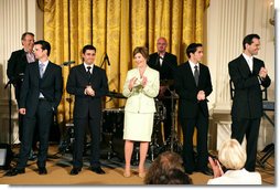 Mrs. Laura Bush stands with members of the cast from the Tony award-winning musical "Jersey Boys" as they perform during a luncheon for Senate Spouses in the East Room, Monday, June 12, 2006. White House photo by Shealah Craighead