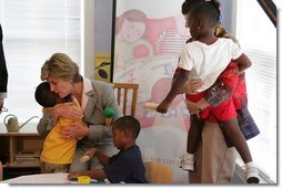 Mrs. Laura Bush receives a hug from a young boy at the House of Tiny Treasures in Houston during her visit Monday, Sept. 19, 2005. The House enables parents to search for jobs and housing, and to run errands while their children receive good care from credentialed teachers.  White House photo by Krisanne Johnson