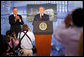 Former President George H.W. Bush leads the applause for his son, President George W. Bush after introducing him during dedication ceremonies Friday, Aug. 8, 2008, for the U.S. Embassy in Beijing. White House photo by Shealah Craighead