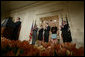 President George W. Bush, left, applauds as he listens to newly confirmed U.S. Supreme Court Justice Samuel Alito address an audience, Tuesday, Feb. 1, 2006 in the East Room of the White House, prior to being sworn-in by U.S. Supreme Court Chief Justice John Roberts, right. President Bush stands with Alito's wife, Martha-Ann, their son, Phil and daughter, Laura. White House photo by Paul Morse