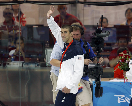 U.S. gold medalist Michael Phelps waves as he leaves poolside Sunday, Aug. 10, 2008, after winning the 400-meter Individual Medley in world-record time at the 2008 Summer Olympics in Beijing. White House photo by Eric Draper