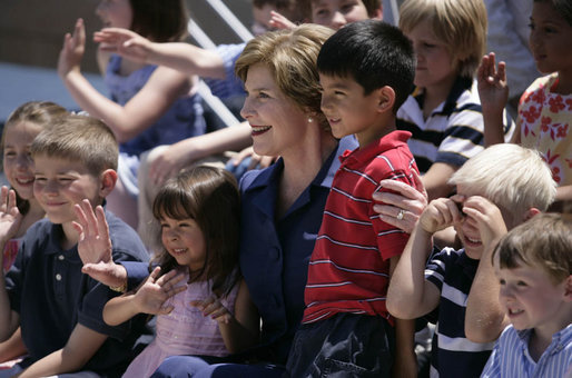 Mrs. Laura Bush sits with children of employees and staff at the U.S. Embassy Monday, in Sofia, Bulgaria, the last stop on a weeklong European visit by she and President George W. Bush. White House photo by Shealah Craighead