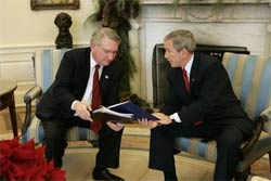 President George W. Bush receives the results of the 2004 Monitoring the Future study from Director John Walters of the Office of National Drug Control Policy in the Oval Office Tuesday, Dec. 21, 2004. The study measures drug, alcohol and cigarette use among adolescent students nationwide. This year's report found that drug use among teens has declined 17 percent since 2001.