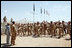 Mrs. Laura Bush is greeted Sunday, June 8, 2008, by New Zealand troops performing a traditional warrior's dance at the Bamiyan Provincial Reconstruction Team Base in Afghanistan's Bamiyan province. Standing with her is Major Justin de la Haye.