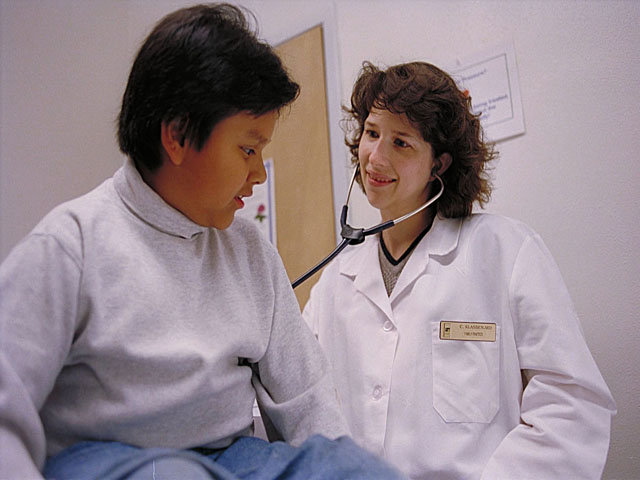This is a photo of a female doctor examining a child.