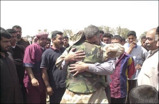 A member of the Free Iraqi Forces (FIF) has a reunion with famly members at Umm Qasr, Iraq,.