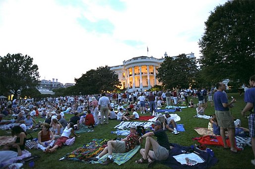 Awaiting a show of explosions of color, White House staff members and their families relax on the South Lawn Thursday, July 4, 2002. Shortly before the fireworks began, President Bush joined the party and watched the display from the Truman Balcony. Watch webcast of Fireworks on the National Mall. White House photo by Tina Hager.