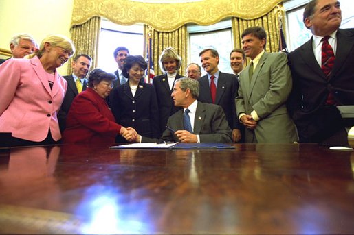 President George W. Bush talks with invited guests Thursday, Aug.1, after signing the Nurse Reinvestment Act of 2002 in the Oval Office. The legislation will create financial assistance programs for nursing students and support the nursing profession through public service announcements. White House photo by Tina Hager.