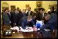 President Bush signs a team jersey for the U.S. Soccer Team in the Oval Office Friday, August 2, 2002. White House photo by Eric Draper.