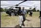 President George W. Bush walks with YMCA volunteer Andrew Simpson after arriving on Marine One in Dallas, Texas, Friday, July 18, 2003. White House photo by Paul Morse