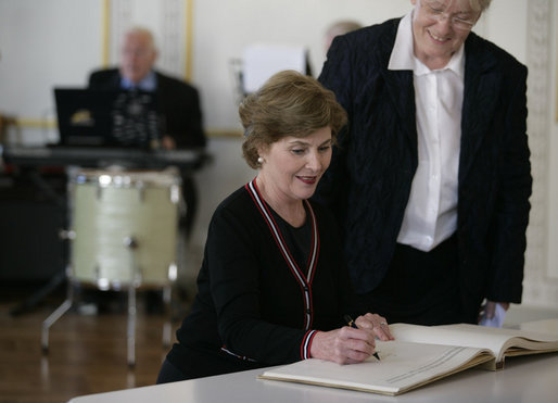 Mrs. Laura Bush signs the Golden Book after arriving at Wismar City Hall in Wismar, Germany Thursday, June 7, 2007, to participate in a program for G8 spouses. Looking on is Dr. Rosemarie Wilcken, Mayor of Wismar. White House photo by Shealah Craighead