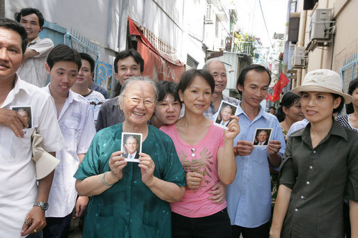 Onlookers line the street of Ho Chi Minh City Monday, Nov. 20, 2006, holding pictures of President George W. Bush, who was joined by Mrs. Laura Bush for a daylong visit to the city. White House photo by Shealah Craighead
