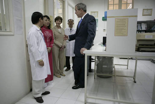 President George W. Bush and Mrs. Laura Bush are briefed as they tour the Pasteur Institute in Ho Chi Minh City Monday, Nov. 20, 2006. 