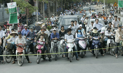 Pedestrians and cyclists line the motorcade route in Hanoi as President George W. Bush and Mrs. Laura Bush head to the Sheraton Hanoi Hotel Friday, Nov. 17, 2006, after their arrival in Vietnam. White House photo by Paul Morse