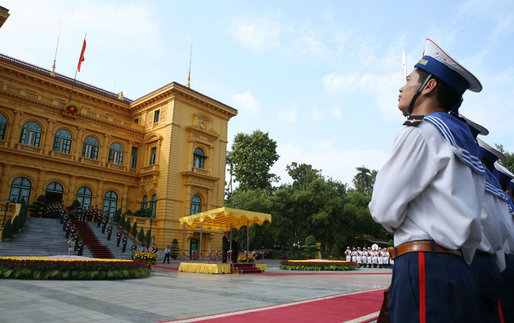 As President George W. Bush and President Nguyen Minh Triet of Vietnam view from a canopy, an honor guard stands at attention Friday, Nov. 17, 2006, during the arrival ceremony at Hanoi's Presidential Palace. White House photo by Paul Morse
