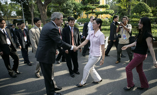 President George W. Bush greets passersby as he walks from Hanoi's Presidential Palace Friday, Nov. 17, 2006, to the Office of the Government where he met with Viet Prime Minister Nguyen Tan Dung. White House photo by Eric Draper