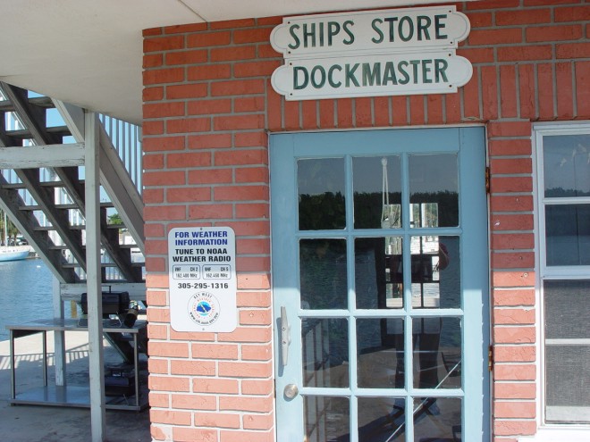 Faro Blanco Oceanside Marina Dockmaster's Office with sign posted to the left of the door