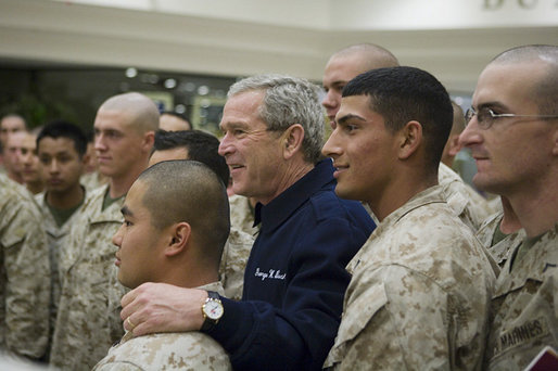 President George W. Bush poses for photos with U.S. Marines headed to Iraq, during a stopover Tuesday evening, Feb. 28, 2006 at Shannon, Ireland's international airport terminal. President George W. Bush meets with U.S. Marines headed to Iraq, during a stopover Tuesday evening, Feb. 28, 2006 at Shannon, Ireland's international airport terminal. President Bush visited with the Marines as part of his five-day visit to India and Pakistan. White House photo by Paul Morse