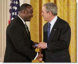 President George W. Bush congratulates Steve Ellis of Carrollton, Texas, upon receiving the President's Volunteer Service Award during a White House celebration of African American History Month. White House photo by Paul Morse