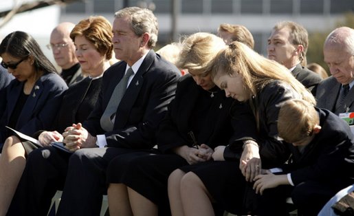 Joining the family of Space Shuttle Columbia Commander Rick Husband, President George W. Bush and Laura Bush bow their heads in prayer during a memorial service at NASA's Lyndon B. Johnson Space Center Tuesday, Feb. 4, 2003. Sitting with the President are Mr. Husband's wife, Evelyn, and children Laura and Matthew. White House photo by Paul Morse