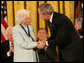 President George W. Bush congratulates Ruth Johnson Colvin after presenting her with the Presidential Medal of Freedom Friday, Dec. 15, 2006, in the East Room of the White House. Said the President, "Ruth Colvin is a person of intelligence and vision and heart. And she has earned the gratitude of many, and the admiration of us all." White House photo by Eric Draper