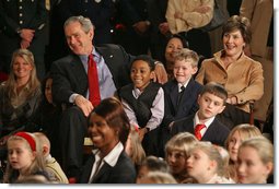 President George W. Bush and Mrs. Laura Bush sit with children of deployed U.S. military personnel and watch a performance of "Willy Wonka" by members of The Kennedy Center Education Department in the East Room Monday, Dec. 4, 2006. White House photo by Eric Draper