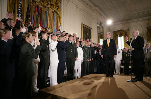 President George W. Bush attends a commissioning ceremony for Joint Reserve Officer Training Corps Thursday, May 17, 2007, in the East Room of the White House, as U.S. Secretary of Defense Robert Gates administers the commissioning oath to the ROTC members. White House photo by Eric Draper