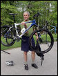 President George W. Bush holds up his mountain bike before riding with members of the President's Council on Physical Fitness and Sports Saturday, May 5, 2007, in Beltsville, Md. "It doesn't take much time to stay fit -- 30 minutes five days a week; 30 minutes of walking, 30 minutes of running, 30 minutes of biking, 30 minutes of swimming on a regular basis will help deal with a lot of health issues here in America," said President Bush, who exercises regularly. White House photo by Joyce Boghosian