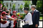 President George W. Bush and Her Majesty Queen Elizabeth II of Great Britain stop to meet a group of children offering flowers Monday, May 7, 2007, during their walk from the White House to Blair House, where the Queen Elizabeth II and His Royal Highness the Prince Philip, Duke of Edinburgh, are staying during their visit to Washington, D.C. White House photo by Eric Draper
