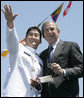 President George W. Bush holds a coin presented to him by U.S. Coast Guard graduate Daniel Kyung-Hyun Han, after President Bush presented him with his commission Wednesday, May 23, 2007, at the U.S. Coast Guard Academy commencement in New London, Conn. White House photo by Joyce Boghosian