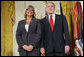 President George W. Bush joins military spouse Cindy Bjerke of Spanaway, Wash., on stage in the East Room of the White House, to receive the President’s Volunteer Service Award Friday, May 11, 2007, during a commemoration of Military Spouse Day. White House photo by Eric Draper