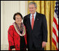 President George W. Bush welcomes Linda Uehara of Mililani, Hawaii, to the stage in the East Room of the White House, to receive the President’s Volunteer Service Award Thursday, May 10, 2007, in celebration of Asian Pacific American Heritage Month. White House photo by Eric Draper