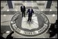 Standing on the agency seal, President George W. Bush speaks to the media inside the CIA headquarters Thursday, March 3, 2005, as CIA Director Porter Goss listens in. White House photo by Paul Morse