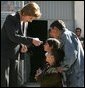 Laura Bush hands red, white and blue kaleidoscopes to youngsters outside a Kabul bakery Wednesday, March 30, 2005 during her visit to Afghanistan. White House photo by Susan Sterner