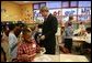 President George W. Bush talks with Kasey Stevenson and other students as he signs autographs during a visit to an after-school classroom program at the Providence Family Support Center in Pittsburgh Monday, March 7, 2005. White House photo by Susan Sterner