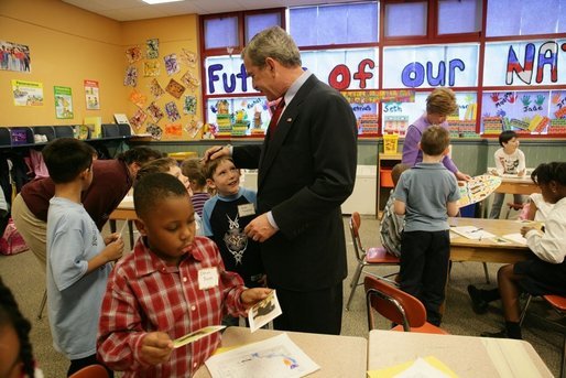 President George W. Bush talks with Kasey Stevenson and other students as he signs autographs during a visit to an after-school classroom program at the Providence Family Support Center in Pittsburgh Monday, March 7, 2005. White House photo by Susan Sterner