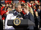 President George W. Bush is presented a team jacket from Paralympian Jennifer Armbruster after delivering his remarks to members of the 2008 United States Summer Olympic and Paralympic Teams Tuesday, Oct. 7, 2008, on the South Lawn of the White House. White House photo by Eric Draper