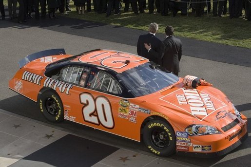 President George W. Bush stands with champion race car driver Tony Stewart, during ceremonies to honor the 2005 NASCAR Nextel Cup Champion team, Tuesday, Jan. 24, 2006, on the South Lawn of the White House. White House photo by Eric Draper