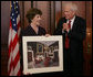 Mrs. Laura Bush is presented with a print by Dr. James Billington, the Librarian of Congress, showing an interior view of the White House as it looked in the early 1900s, Wednesday, April 26, 2006 during the James Madison Council Luncheon at the Library of Congress. White House photo by Kimberlee Hewitt