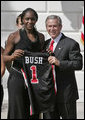 President George W. Bush stands with Crystal Langhorne, captain of the University of Maryland Women's Basketball Team, during a South Lawn ceremony honoring the 2005 and 2006 NCAA champions Thursday, April 6, 2006. The University of Maryland also won national titles in women's field hockey and men's soccer. White House photo by Paul Morse