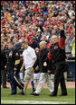 U.S. Army Sgt. Paul Brondhaver, left, U.S. Army Sgt. Mike McNaughton, center, and John Prazynski accompany President George W. Bush to the pitchers mound during the opening game between the Cincinnati Reds and the Chicago Cubs in Cincinnati, Ohio, Monday, April 3, 2006. The three men are involved with Impact Player Partners, an Ohio-based group that provides support for wounded soldiers and their families. White House photo by Eric Draper