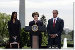 Mrs. Laura Bush addresses the audience Wednesday, April 26, 2006, as President Bush and Kim Oliver, the 2006 National Teacher of the Year, look on during a ceremony on the South Lawn honoring Ms. Oliver and the State Teachers of the Year.  White House photo by Paul Morse