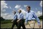 President George W. Bush walks with Minnesota Governor Tom Pawlenty, left, and Sen. Norm Coleman during a visit to the Katzenmeyer family farm in Le Sueur, Minn., Wednesday, Aug. 4, 2004. White House photo by Eric Draper.