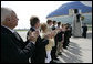 President George W. Bush is applauded by a welcoming committee of state and local community leaders as he arrives at Austin Straubel International Airport in Green Bay, Wis., Thursday, Aug. 10, 2006. After greeting the welcoming committee President Bush spoke to reporters on the airline bombing plot uncovered in the United Kingdom, saying it is "a stark reminder that this nation is at war with Islamic fascists who will use any means to destroy those of us who love freedom, to hurt our nation." White House photo by Eric Draper