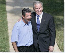 President George W. Bush smiles as he stands with Rockey Vaccarella during a statement to the media Wednesday, Aug. 23, 2006, on the White House lawn. Vaccarella, who lost his home in the wake of Hurricane Katrina and who drove to Washington D.C. to speak directly to the President, told reporters, "I just don't want the government and President Bush to forget about us," adding, "If we had this President for another four years, I think we'd be great." White House photo by Kimberlee Hewitt