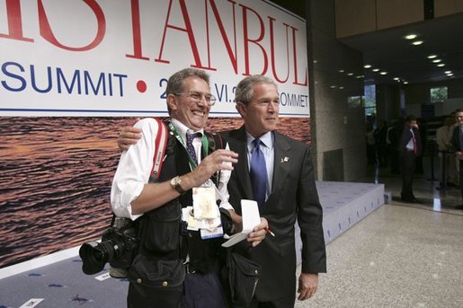 After participating in the official group photo of NATO leaders, President George W. Bush grabs Reuters photographer Larry Downing for a quick photo op of his own during the NATO Summit at the Istanbul Convention and Exhibition Center in Turkey, Monday, June 28, 2004. White House photo by Eric Draper.